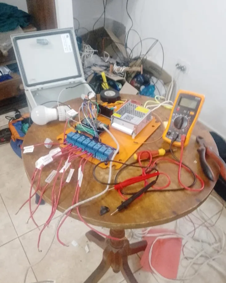 Banco de trabajo durante el armado de una caja de control: la caja abierta, el bloque de relés, la fuente y los cables etiquetados uno por uno.